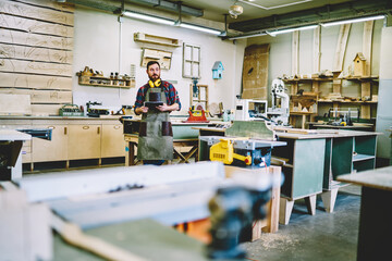 Wall Mural - professional forman in apron and wear for safety standing in workshop checking clients ordering for 