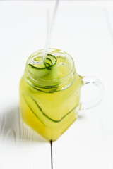 Wall Mural - A refreshing summer lemonade with cucumber in a jar, on white wooden table