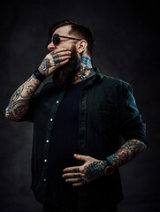 Wall Mural - Bearded tattooed guy yawns covering his mouth with his hand
