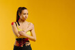 © dsheremeta - Young caucasian girl with kinesiology tape on her belly and leg, on yellow background. Sport and rehabilitation, kinesiotherapy treatment.