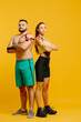 © dsheremeta - Professional athletes, man and woman with kinesiological tape on the body, posing on a yellow background. Sports and rehabilitation, kinesiotherapy treatment