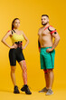 © dsheremeta - Professional athletes, man and woman with kinesiological tape on the body, posing on a yellow background. Sports and rehabilitation, kinesiotherapy treatment