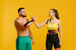 © dsheremeta - Professional athletes, man and woman with kinesiological tape on the body, posing on a yellow background. Sports and rehabilitation, kinesiotherapy treatment