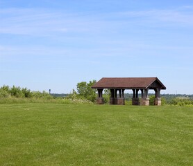 The wood shelter in the park on a bright sunny day.