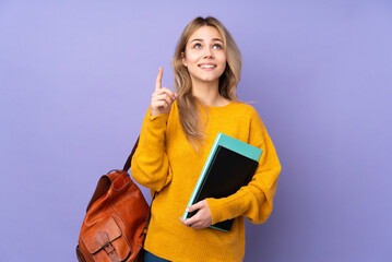 Wall Mural - Teenager Russian student girl isolated on purple background pointing up and surprised