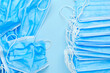 Used and new blue protective surgical masks on the blue background with copy space. Delivery of medical tools to the hospital. Medical consumables