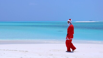 Wall Mural - Man in Santa Claus costume on sandy tropical beach. Christmas and New Year celebration on island