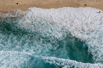 Wall Mural - Top view of waves breaking into the sand at the beach, aerial photography, photo taking from helicopter looking down