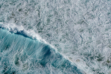 Wall Mural - Top view of waves breaking into the sand at the beach, aerial photography, photo taking from helicopter looking down