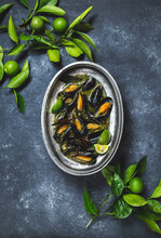 Mussels In Green Herb And White Wine Sauce With Lemon On Dark Background.