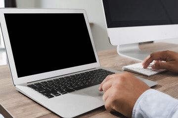 Man of business man hand working on laptop computer on wooden desk Laptop with blank screen on table.