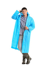 Wall Mural - Young Asian man in raincoat on white background