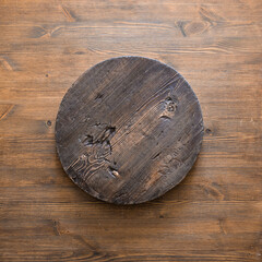 round wooden plate on old wooden background