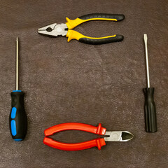 screwdriver and forceps engineer hand tool folded into a square frame on a dark base