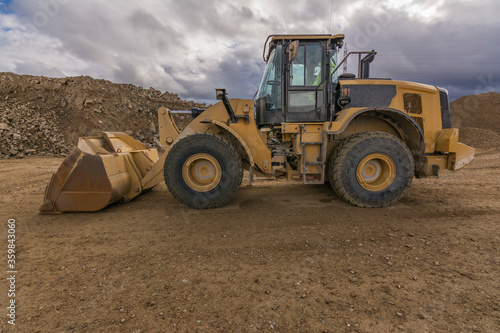 Fotomural Yellow excavator moving earth at a construction site