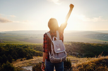 Young hipster girl enjoy sunset on viewpoint. Travel woman with backpack