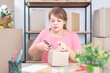 © LOVEis - Selling online work from home. Women business owner working at home with packing box on the workplace - online shopping