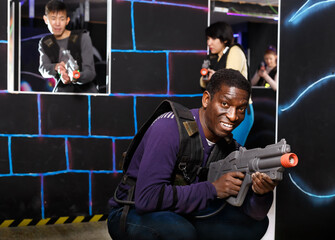 Wall Mural - African man playing laser tag with friends