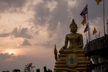 Buddha statue in Thailand. The man in the traditional wear not in the focus.Sunset at the Temple. Monk in the Temple. The Big Buddha statue in Phuket.