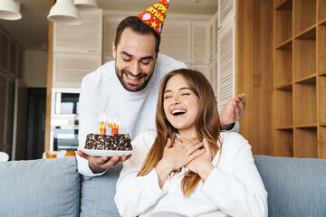 Wall Mural - Cheerful attractive young couple celebrating birthday