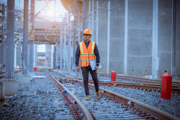 Wall Mural - Engineer under inspection and checking construction process railway switch and checking work on railroad station .Engineer wearing safety uniform and safety helmet in work.