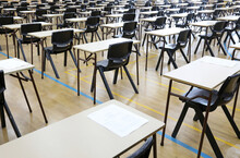 View Of Large Exam Room Hall And Examination Desks Tables Lined Up In Rows Ready For Students At A High School To Come And Sit Their Exams Tests Papers.