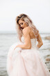 © Наталья Котковец - portrait of a sexy bride in water . A girl with loose hair in a soft pink dress, against the background of the sea.