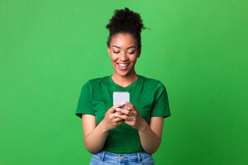 Smiling afro girl using cell phone at studio