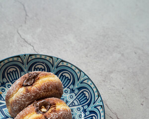 Bomboloni, a donut filled with melted chocolate and eaten as a snack. Bomboloni originated from italy.