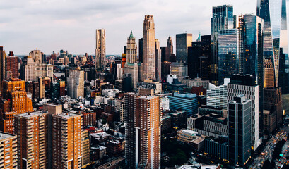 Wall Mural - Aerial view from helicopter sightseeing tour around Manhattan Island. Scenery skyline with contemporary skyscrapers of downtown financial district in New York. Dramatic sky above cityscape metropolis