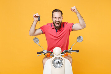 Wall Mural - Happy young bearded man guy in casual summer clothes driving moped isolated on yellow background studio. Driving motorbike transportation concept. Mock up copy space. Hold keys, doing winner gesture.