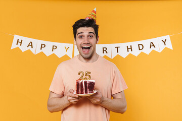 Poster - Photo of excited man in party cone holding birthday cake and smiling