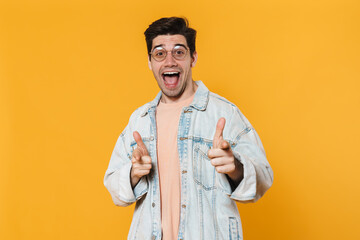 Canvas Print - Photo of excited young man in eyeglasses pointing fingers at camera