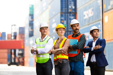 Wall Mural - Group of professional dock worker and engineering people wearing hardhat safety helmet and safety vest standing and working at container yard port of import and export. Business teamwork concept