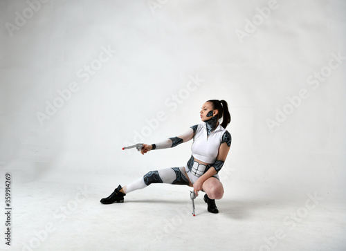 Fotografía beautiful girl in robot clothes posing with silver revolvers