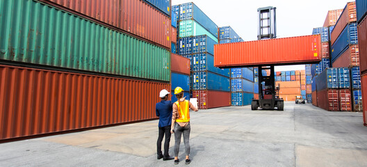 Wall Mural - Man manager and woman Supervisor dock cargo checking and control loading Containers box at container yard port of import and export goods. Unity and teamwork concept