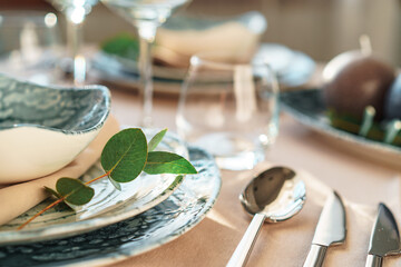 Beautiful elegant table setting with green stylish dishware and silver cutlery