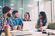 © BullRun - Group of creative young people dressed in casual wear cooperating on development of startup project during meeting in office.Team of creative designers collaborating during brainstorming