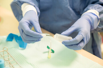 Nurse carefully prepares the material to perform a blood draw on a patient, following safety protocols.