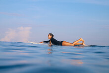 Happy Woman Lying On Surfboard In The Sea, Bali, Indonesia