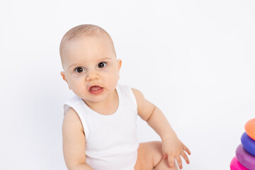 portrait of a Baby 8 months old boy on a white isolated background in white clothing, children's fashion, advertising of children's products, space for text