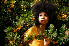 Portrait Of Young Woman Surrounded By A Bush With Yellow Berries