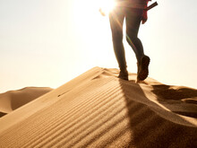 Low Section Of Woman Waking On The Ridge Of A Dune In The Desert, Walvis Bay, Namibia