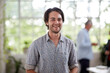 © Bec Hannaford/Austockphoto - Young professional man standing in an open plan office