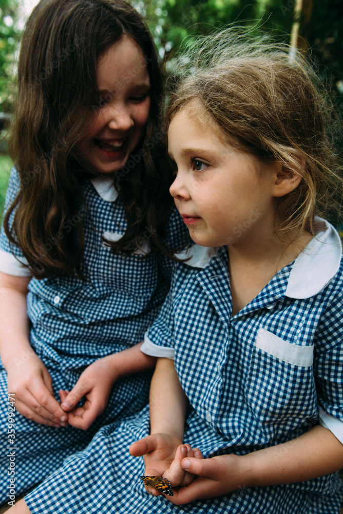 Girls in school uniform sitting outdoors Stock Photo | Adobe Stock