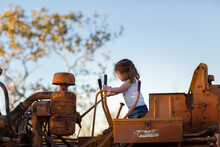 Girl Sitting On Bulldozer Outdoors