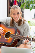 Girl Playing Guitar In Her Bedroom