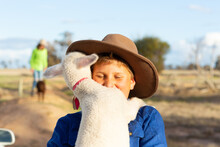 Boy Wearing Hat Holding His Pet Lamb