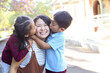 © Claire Bonnor/Austockphoto - Young girl and boy in school uniform, hugging their mother.