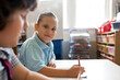 © Claire Bonnor/Austockphoto - Primary school girl facing the camera in a classroom whilst writing